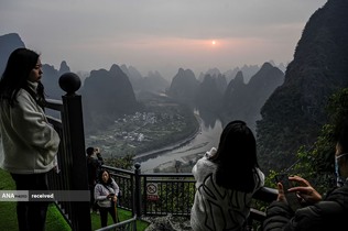 گردشگران در طلوع خورشید را در یک نقطه گردشگری خوش منظره در ساحل غربی رودخانه لی در جنوب چین 