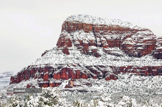 نمایی از کلیسای صلیب مقدس پس از طوفان زمستانی در سدونا، آریزونا، در کنار صخره‌های قرمز پوشیده از برف دیده می‌شود.