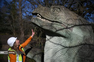 بررسی یکی از مجسمه‌های دایناسورهای در معرض خطر پارک کریستال پالاس، لندن