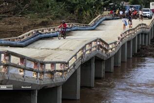 عبور مردم از روی پل آسیب دیده در اثر طوفان اسکار در شهر ایمیاس در استان گوانتانامو، کوبا