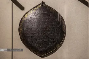 لوح فولادی زیارت نامه"زیارت جامعه صغیره به شکل ترنج و خط نسخ با نقوش طلاکوب گیاهی در نمایشگاه آثار منتخب گنجینه آستان قدس رضوی