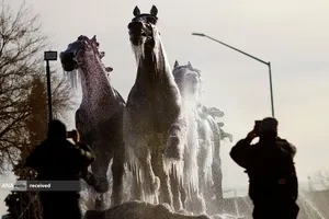 تصویر برداری مردم از یک بنای یادبود پوشیده از یخ در سیوداد خوارز، مکزیک