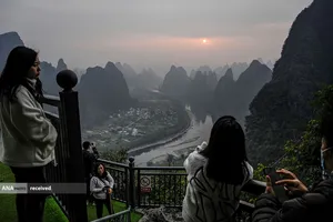 گردشگران در طلوع خورشید را در یک نقطه گردشگری خوش منظره در ساحل غربی رودخانه لی در جنوب چین 