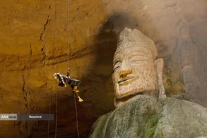 فرود یک توریست از غار تیانیان برای بازدید مجسمه بودا