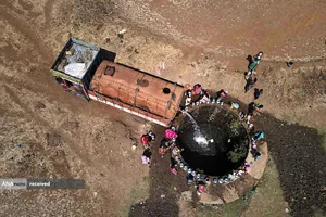 نمایی از تانکری در نزدیکی بمبئی هند که آب را به داخل چاهی تخلیه می&zwnj;کند و زنان از آن آب می&zwnj;کشند.
