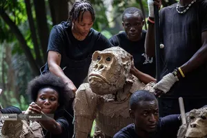 عروسک&zwnj;بازان در کنار یک عروسک گوریل در اندازه واقعی در رویداد هنری و اقلیمی گله&zwnj;ها در کینشاسا، جمهوری دموکراتیک کنگو