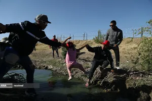 عبور مهاجران مکزیکی از رودخانه ای در مرز آمریکا