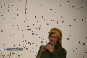 باتلاق خلیج&zwnj;فارس - یکی از اعضای شاخه نظامی گروه اپوزیسیون کرد-ایرانی &laquo;سازمان مبارزه کردستان ایران&raquo; معروف به &laquo;خبات&raquo;، در مقابل دیواری پر از ترکش ایستاده است